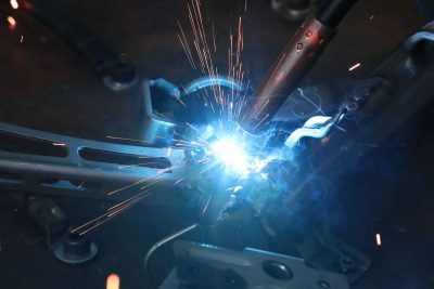 a welder welding a piece of metal with sparks