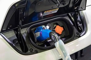 Electric car at charging station with the power cable supply plugged