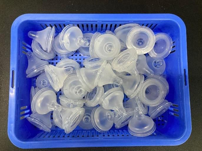 Baby bottle nipples semi-transparent baby bottle nipples in a blue bin ready for bin picking