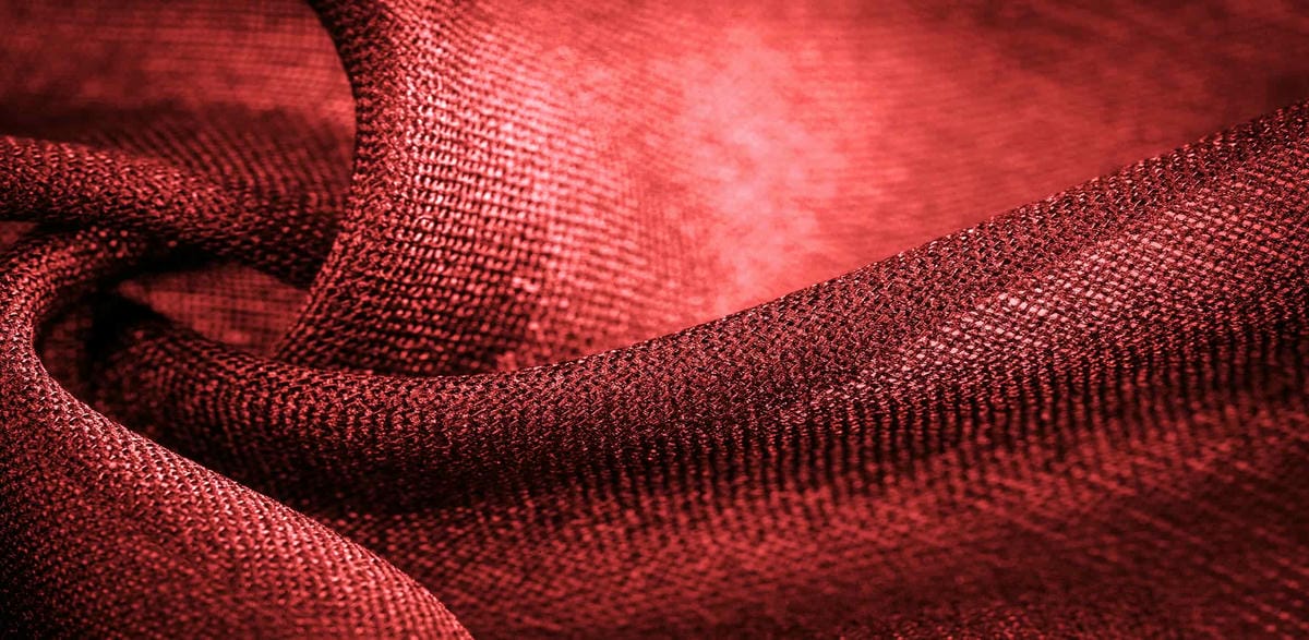 Red Woven Fabric Silk fabric with red stripes. Abstract silk tones in ruby tones. Vintage pattern on the fabric. Background texture, decorative ornament