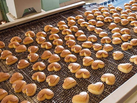 a conveyor belt filled with lots of baked snacks