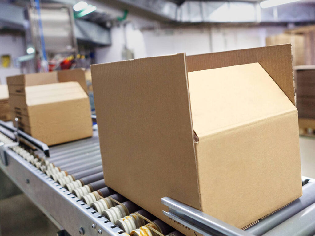 cardboard box moving along a conveyor in a warehouse