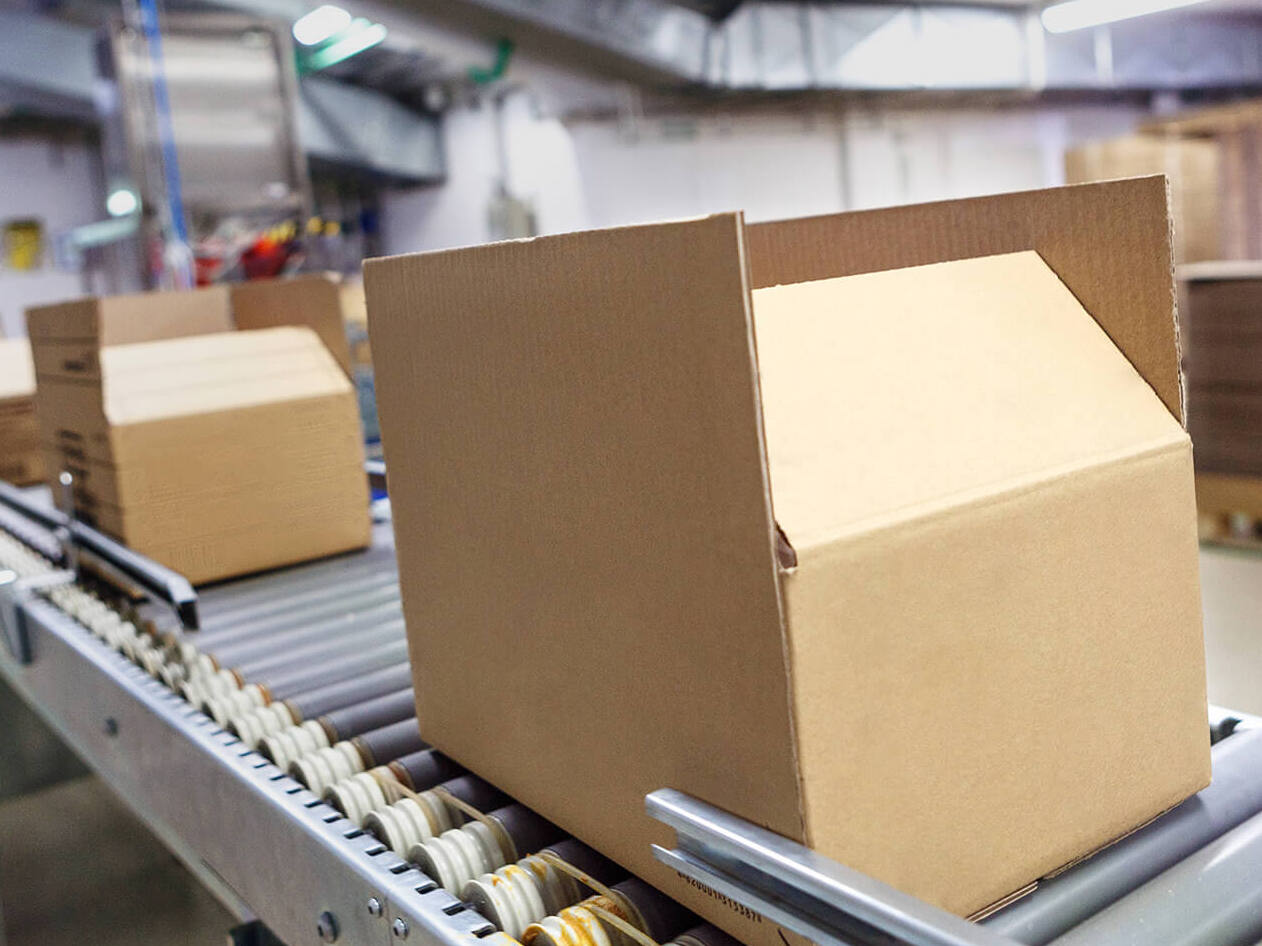 cardboard box moving along a conveyor in a warehouse