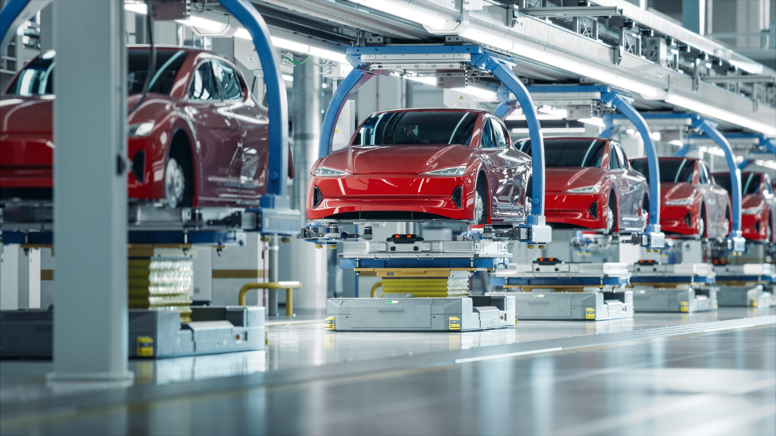A pristine red electric vehicle moving along an advanced automated assembly line in a brightly lit, futuristic car manufacturing plant. This illustrates the crucial role of AI vision in the automotive industry for automated quality inspection, precision assembly verification, and robotic guidance during car production.