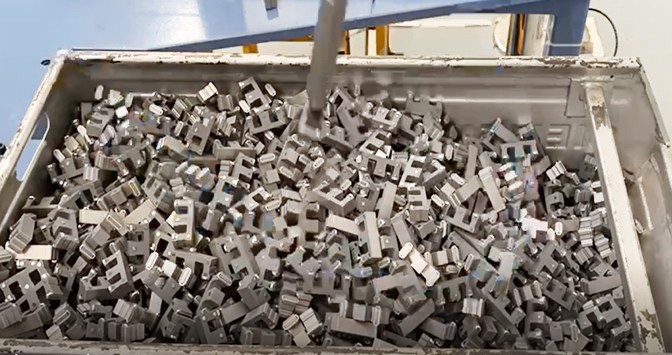 Robotic Bin Picking Robotic bin picking of randomly oriented steel switchgear parts from a metal bin in a manufacturing cell, showcasing industrial AI vision automation.