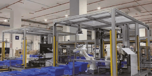 robot arms picking luxury items from blue bins inside a logistics hub