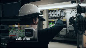 META-aivi AR Wearable AI for Industrial Safety Inspection and Real-Time Validation Industrial worker wearing META-aivi AR smart glasses inspecting an electrical control panel with AI-powered validation overlays, including error detection and real-time verification.