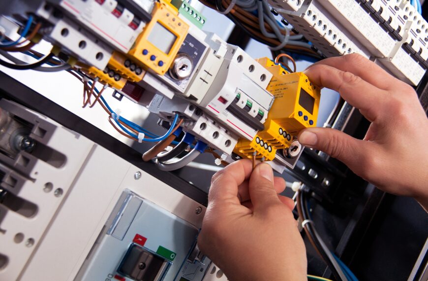 an electrician inspecting a wiring panel inside a smart factory