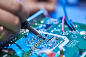 Technician works on electronic components during PCB assembly and inspection.