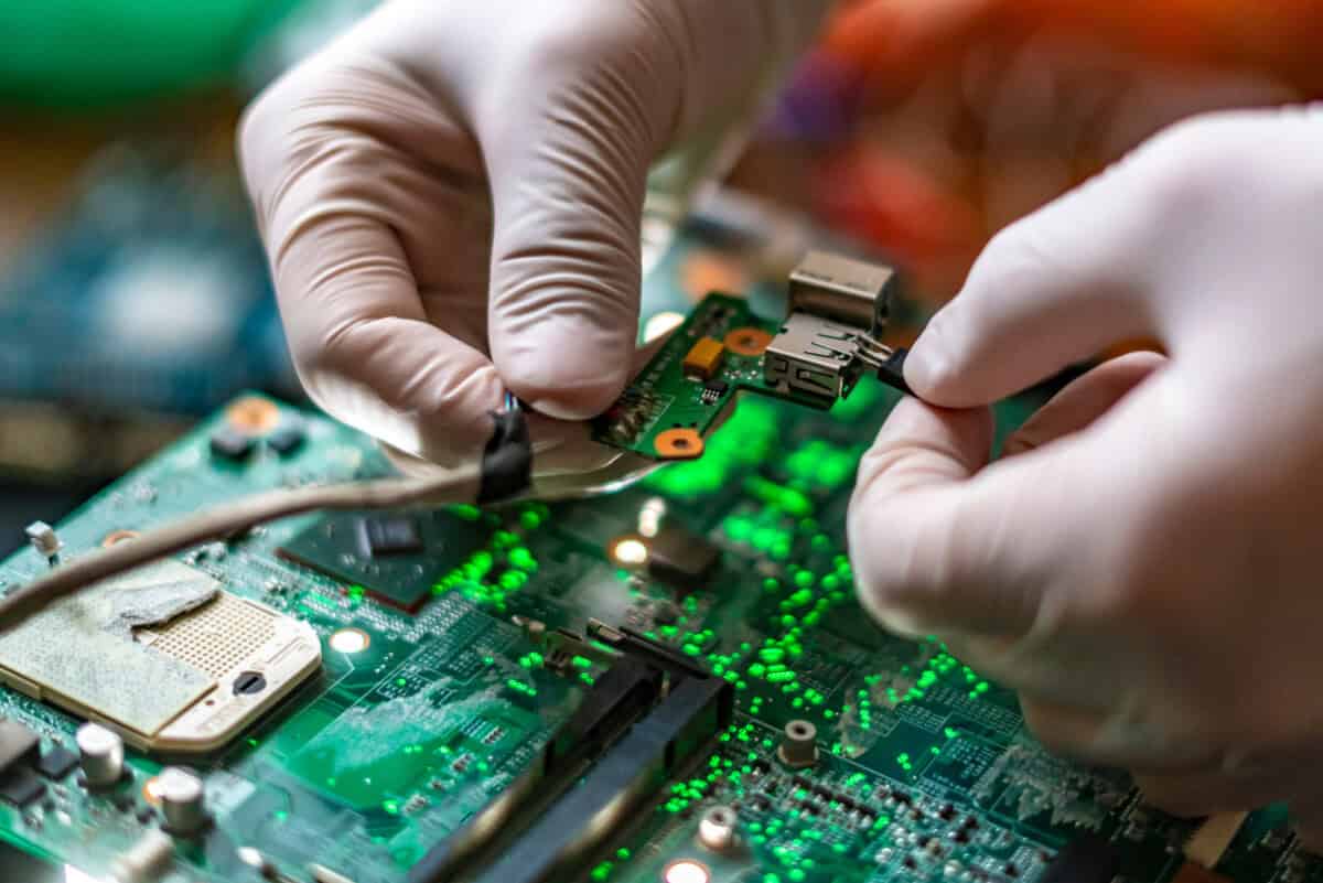 Technician installs a connector on a printed circuit board during PCB assembly verification and quality inspection.