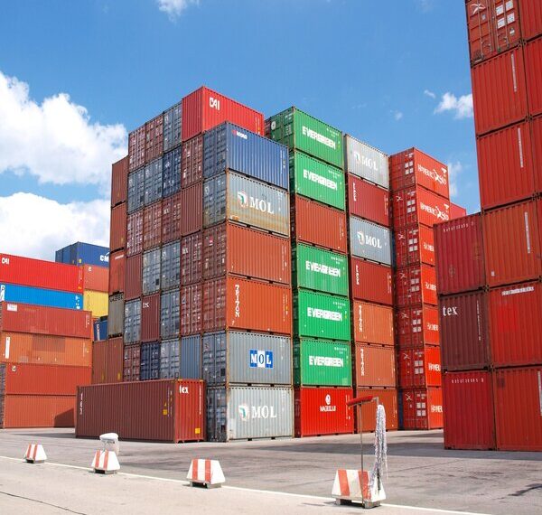 shipping containers of assorted colors stacked in a port