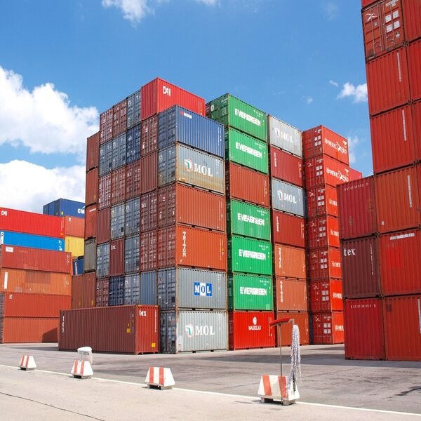 shipping containers of assorted colors stacked in a port