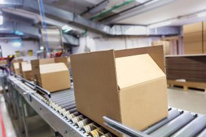 Cardboard box moving along a conveyor in a distribution center Cardboard box moving along a conveyor in a distribution center