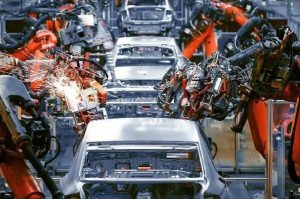 Cars on an automotive production line being welded by robots