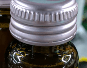 Missing Text Example of missing printed batch or date code on aluminum bottle caps for OCR inspection reference.