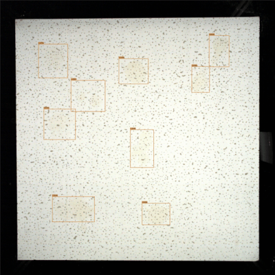 Contaminación Superficial SolVision AI detecta contaminación superficial en un panel de pladur, resaltando manchas y marcas de suciedad mediante cajas delimitadoras durante la inspección automatizada.