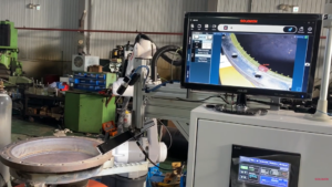 Industrial work cell showing SolVision AI inspecting HVAC welds in real time, displaying defect detection results on the monitor.