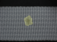 SolVision detects and highlights a hole defect in ribbon fabric during AI-based visual inspection.