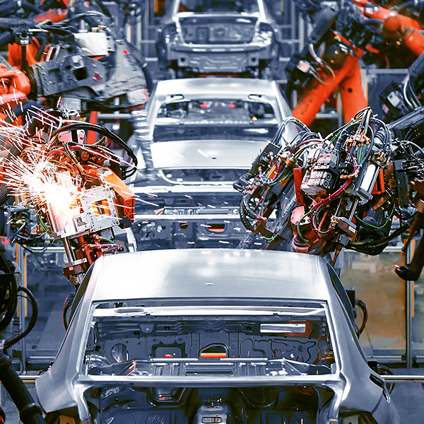 an assembly line of cars with robots working on them